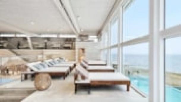 udsigt fra saunaen gennem panoramavindeuerne til pool og strand